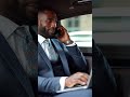 a handsome african-american man dressed in a tailored business suit sitting in one of the car sea...