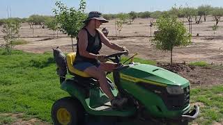 Laurie is mowing the lawn on her John Deere tractor when an unexpected visitor steals the spotlight