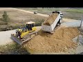 Full team work heavy dump truck unloading soil fillingstronger dozer pushing soil fill land