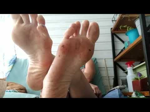 Dirty size 12 feet propped up by long legs, blue toenail polish