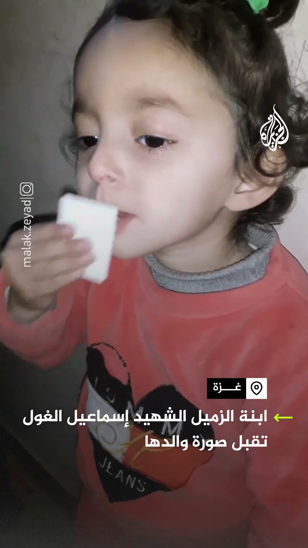 ابنة الزميل الشهيد إسماعيل الغول تقبل صورة والدها