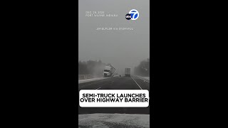 Semi-truck launches over highway barrier