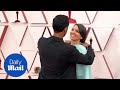 Riz ahmed helps wife fatima farheen mirza with her hair at the oscars