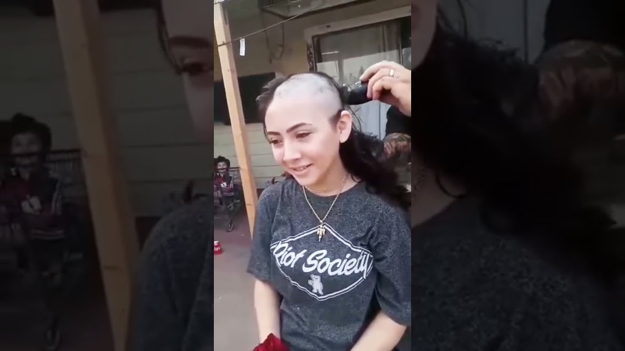 Shaving the girl's head.