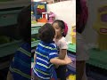 2 year old baby kissing girl in play area