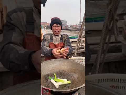 Pescador chinês cozinhando e comendo deliciosos frutos do mar