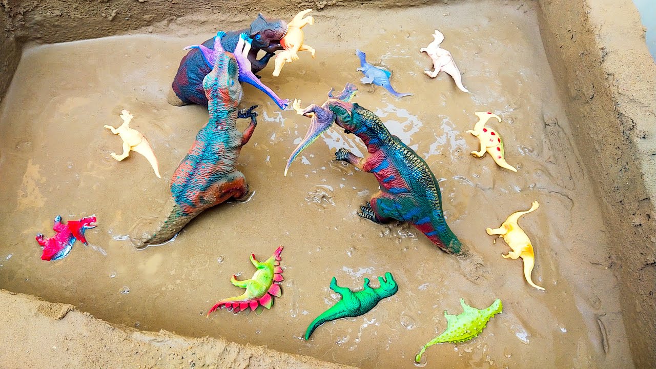 Plastic Toy Dinosaurs Stuck in the Sandbox Velociraptor Triceratops