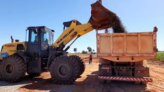 Pá carregadeira W190B New Holland carregando  caçamba de brita na BR153