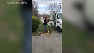 Woman can't stop laughing as brother holds mailbox for delivery
