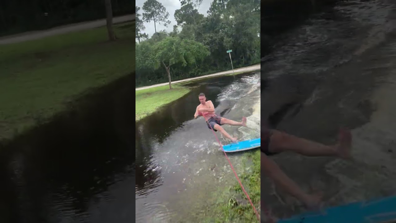 Guy rides boogie board standing up while holding on rope connected to truck after Hurricane Milton