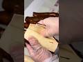 peeling several fresh cassava roots precisely using a manual gloved hand