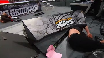 Seth Rollins powerbombs Baron Corbin through Announce table