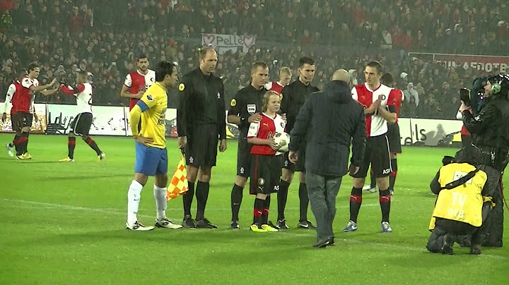 Mascotte Corina en de spelers op het veld
