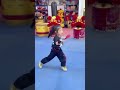 A five-year-old girl wields a guandao, a traditional pole weapon used in Chinese martial arts.