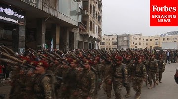 Thousands Of Syrian Soldiers March To Commemorate One-Year Anniversary Of Assad Regime
