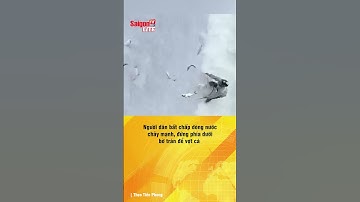 Người dân bất chấp dòng nước chảy mạnh, đứng phía dưới bờ tràn để vợt cá