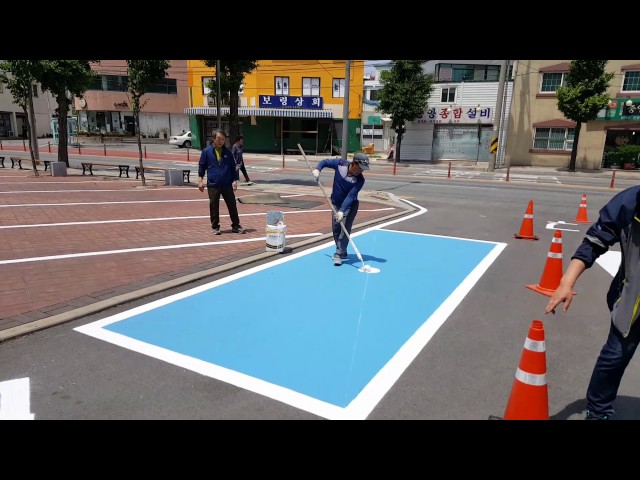 Todo un artista... pintando la señal de una plaza de aparcamiento para discapacitados
