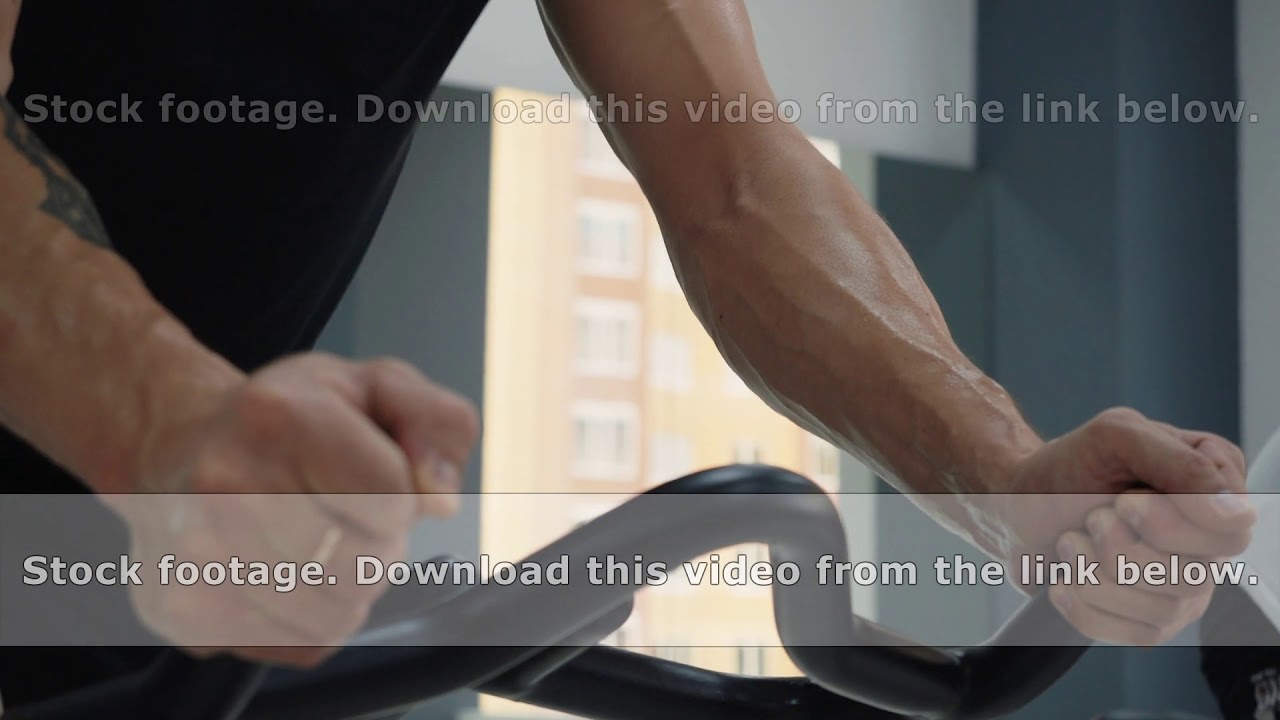 Male sweating hands holding handle indoor bike on cycling class. Wet