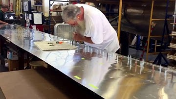 Riveting one of the wing flaps to a B-17 Flying Fortress.