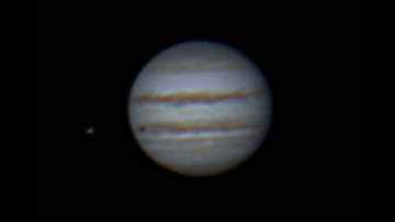 Jupiter rotating forwards and back with one of her moons transiting.