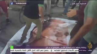متظاهرون يسقطون صورة الرئيس السيسي في ميدان المحافظة بمدينة المنصورة