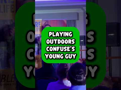 YOUNG GUY IN AUDIENCE CONFUSED BY OLD OUTDOOR GAMES