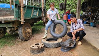The girl mechanic helps the tractor driver fix a flat tire