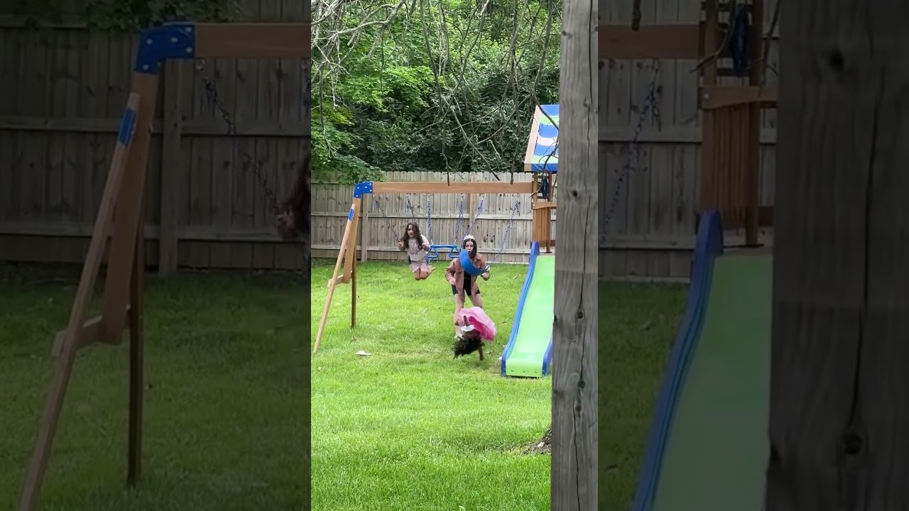 Little girl gets pushed on swing in backyard then flips backwards and bumps head on grass