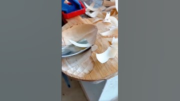 Detailed hand carving of textured wood surface using precision chisel craftsmanship