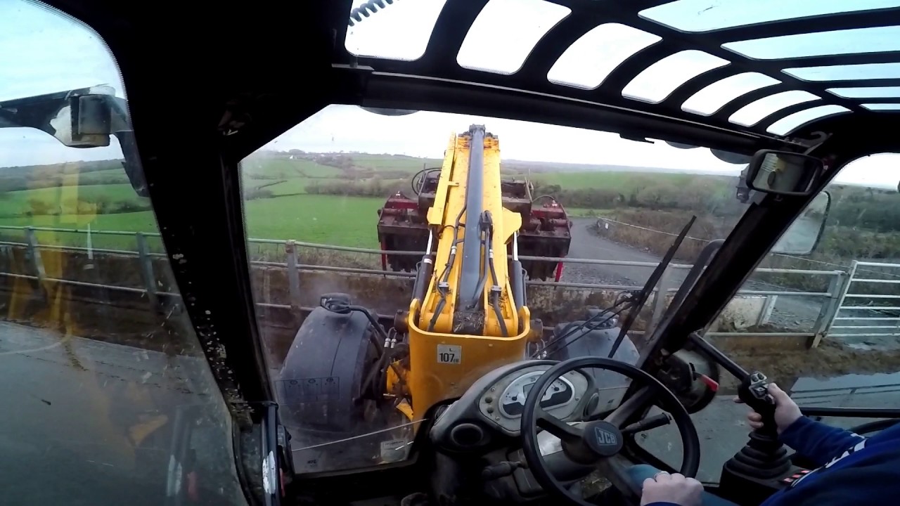 In cab view of feeding cows on jcb 310s