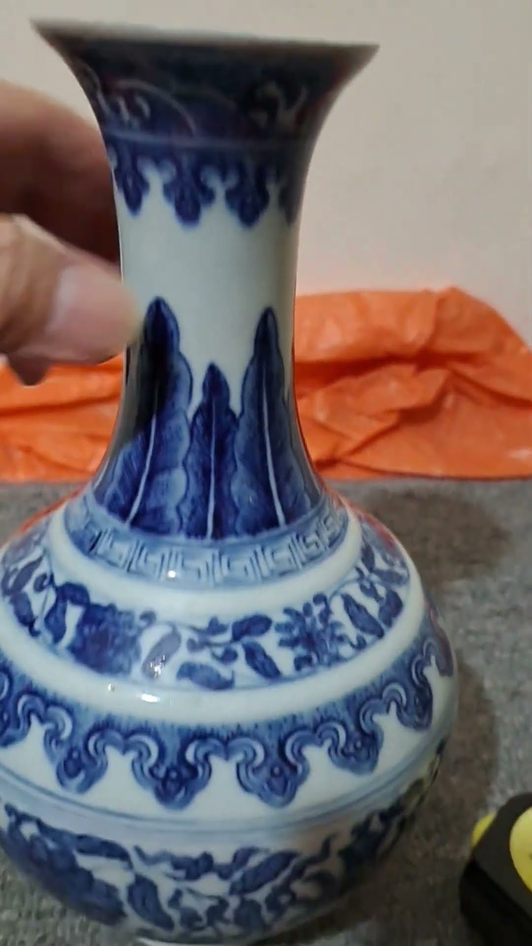 A small blue-and-white porcelain vase with a floral scroll design