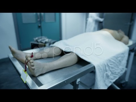 dead-body-on-an-autopsy-table-being-studied-by-the-medical-examiner.-stock-footage