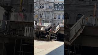 Inline skater grinds handrail in front of old building then falls and lands on his shoulder