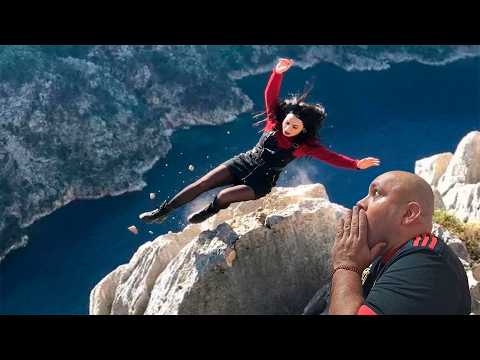 Woman falls while posing for photo on cliff.