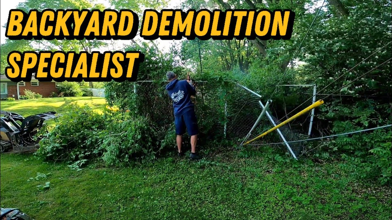 John Schott using mini skid steer to remove overgrown dog kennel and debris.