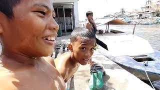 Children swim and jump into a canal near Manila Philippines.