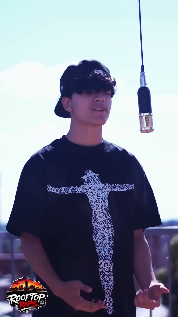 Lil Luciano performing under the hanging mic on a rooftop