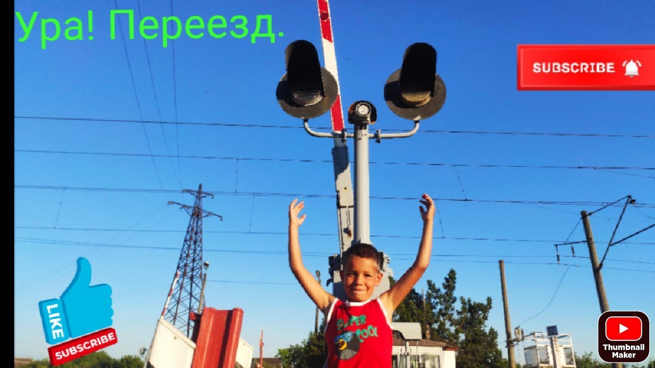 Железнодорожный переезд, пассажирский поезд, шлагбаум и грузовой поезд.