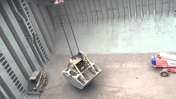 Grab collecting last remaining cement clinker from ship hold