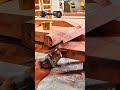 Angle grinder hums steady smoothing wood surface near brass fittings