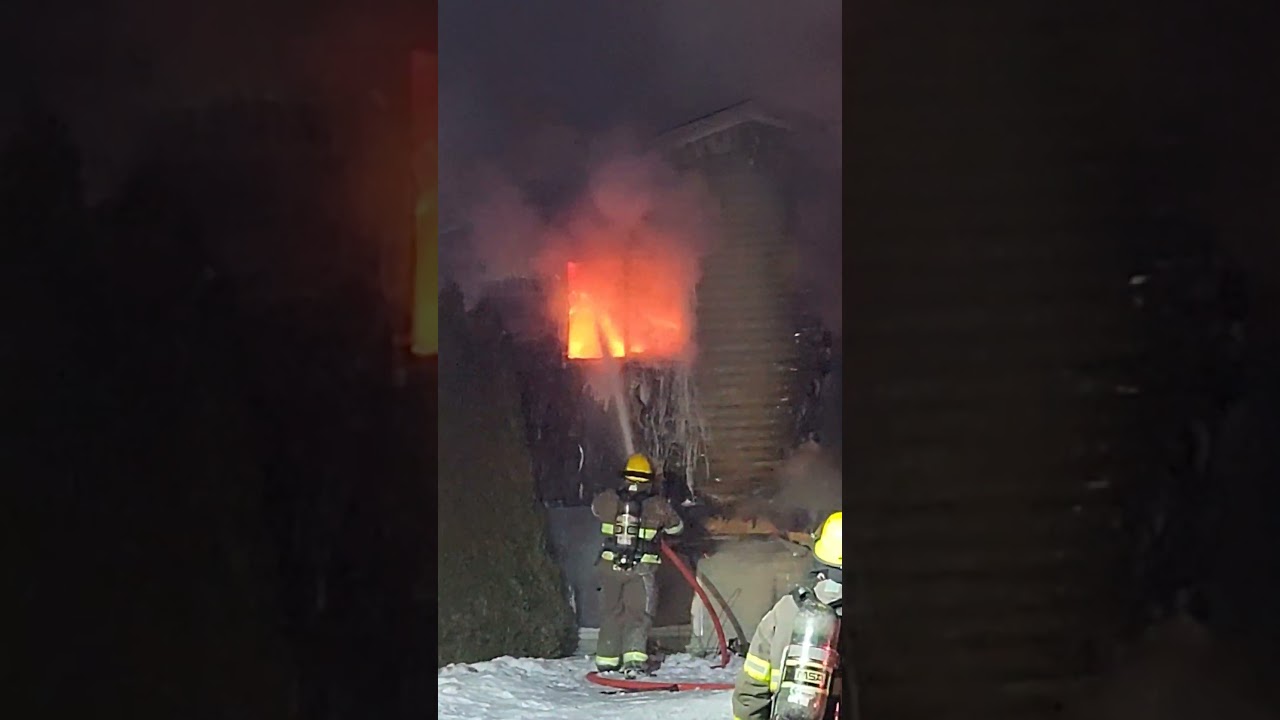 SJRFD Firefighter dousing active flames at a house fire in the City of Mount Pearl