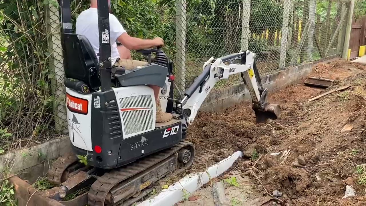 BOBCAT retirando excesso de material sob calçada