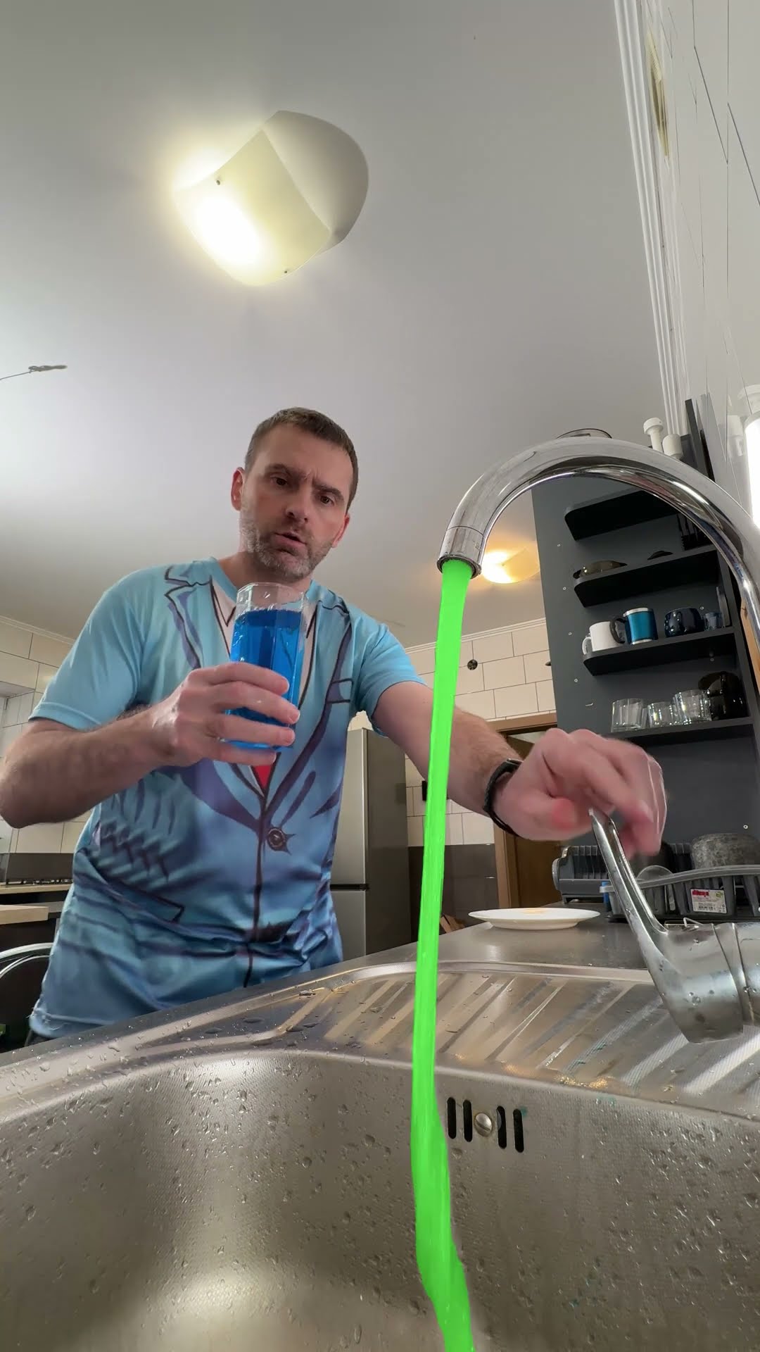 He pours water into a glass, turning off the tap.