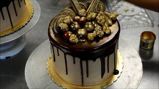 Chocolate cake covered in buttercream icing designed with gold eatable
decoration covering the top of