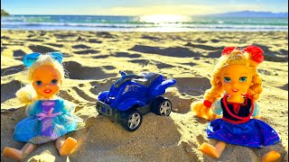 Elsa and Anna toddlers ride a toy quad on the beach