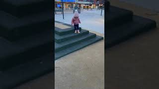 Little kid walks down steps at playground then falls forward and balances on head (Headstand)