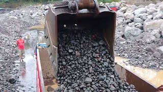 excavator working in sand mining loading small rocks into dump truck - 4k