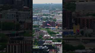 American flag waving over Chicago cityscape with urban buildings, busy Kennedy Expressway, distant