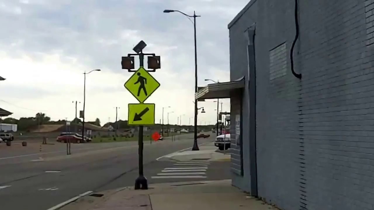 tourism videos london Staples Minnesota walking by buildings and car lot.