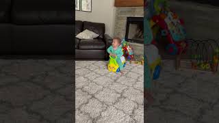 Little girl walks using toy car walker then falls forward and faceplants on carpet